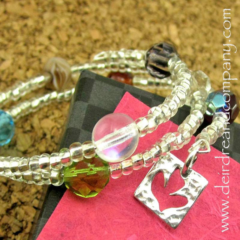 clear-glass-bead-bracelet-with-a few-colorful-beads-and-dove-silver-charm